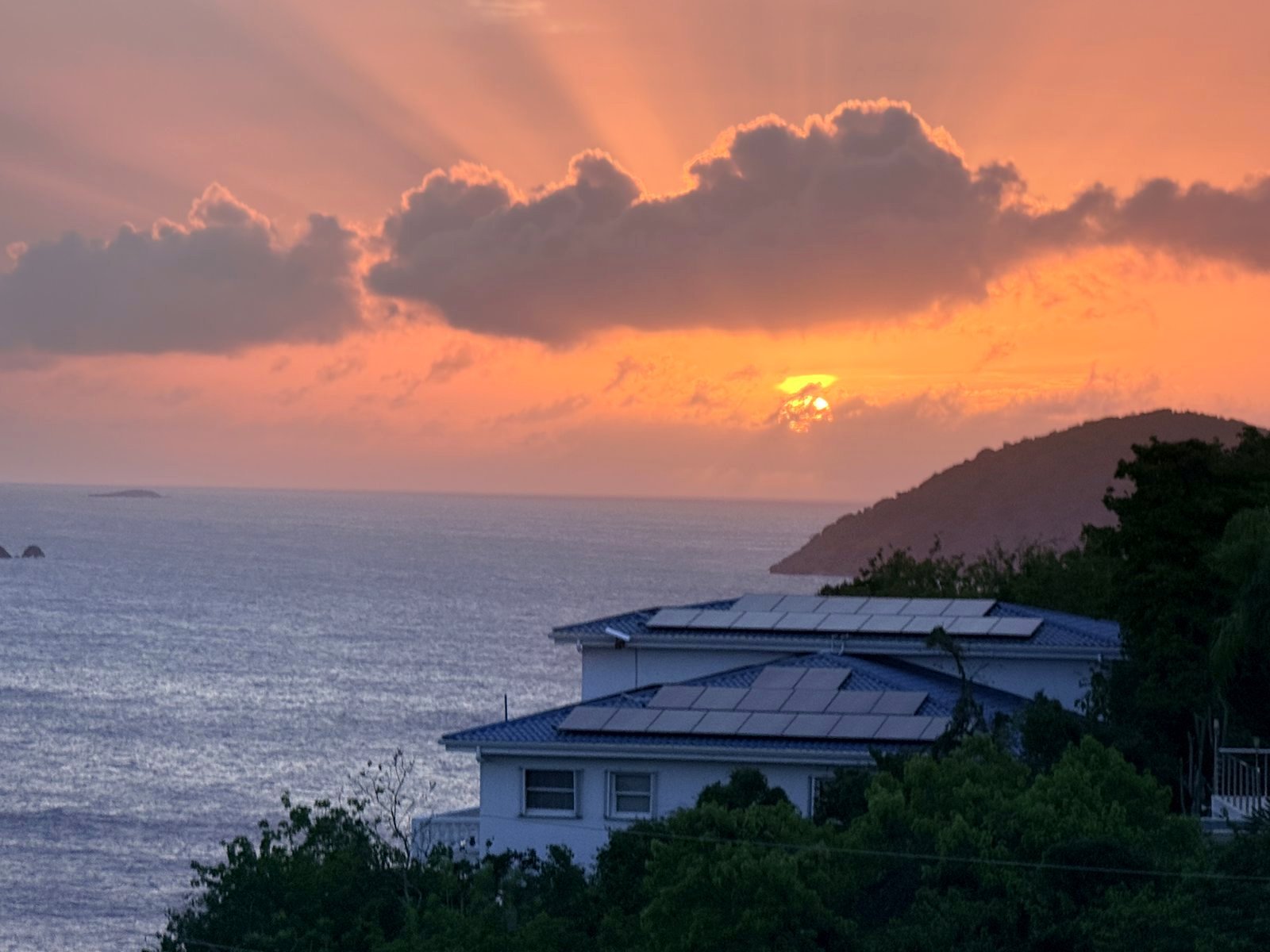 A charter boat under way in clear Virgin Islands water at golden hour